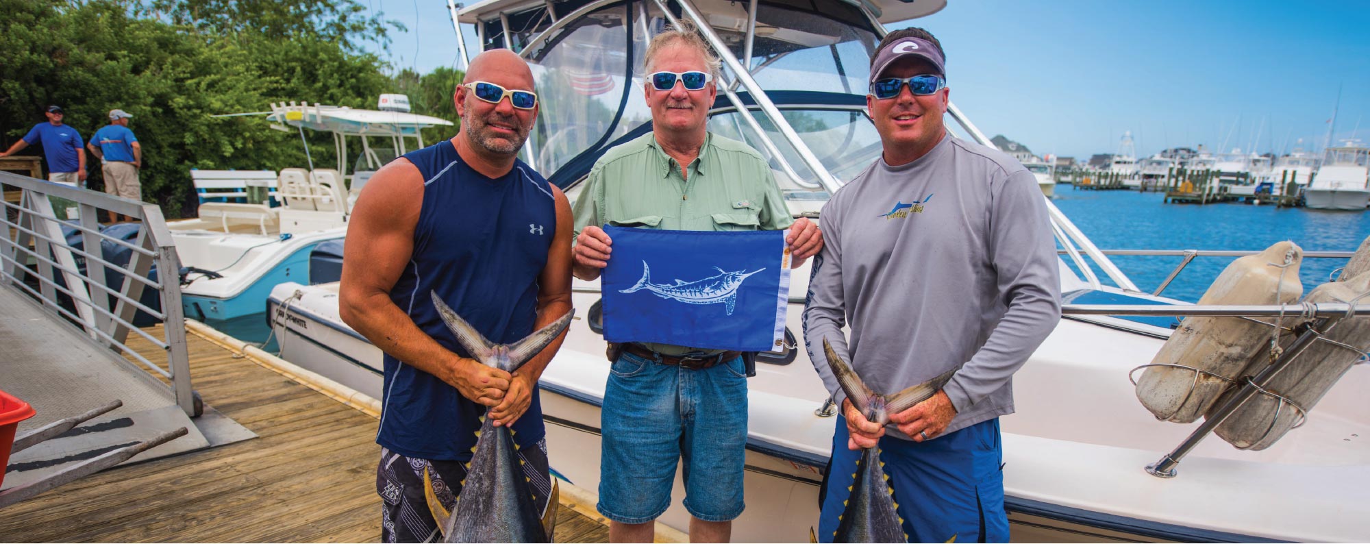 Three men with Tuna and Marlin flag